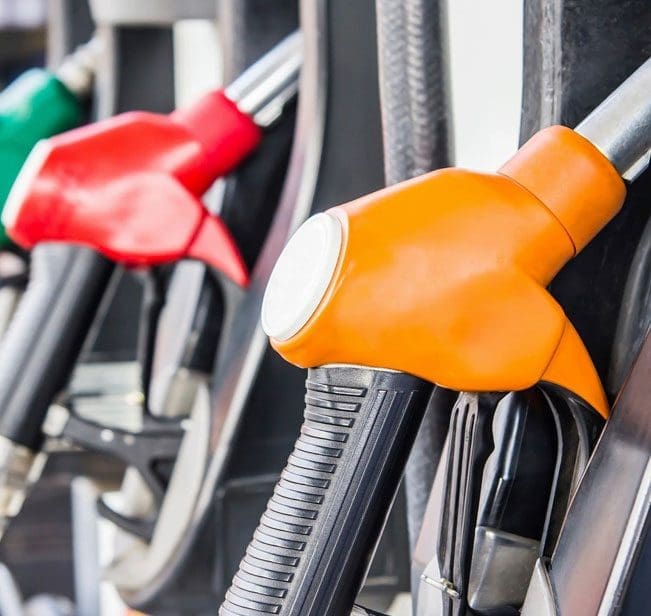 A row of gas pumps with different colors.