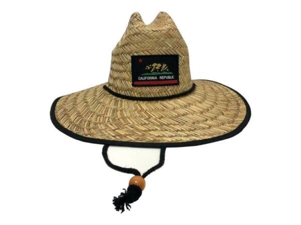 A straw hat with a black trim and a patch.